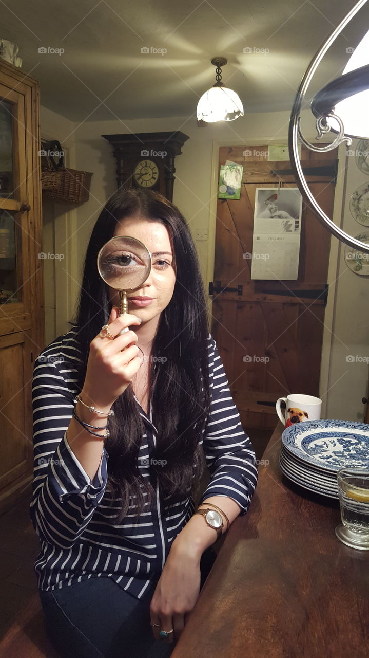 Beautiful woman looking through a magnifying glass