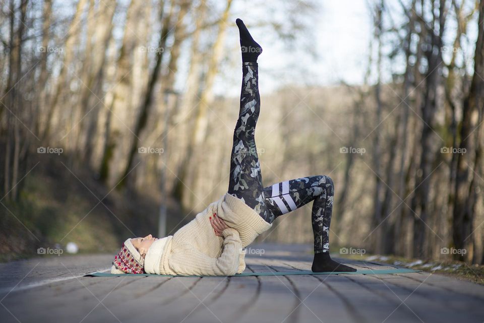 Young woman doing hatha yoga exercises outdoor