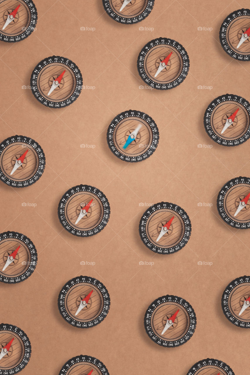 Arranged compasses on brown background