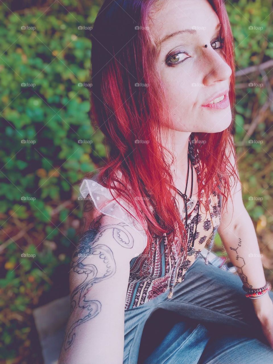 Woman sitting in her garden loving her environment, hippie Sunrise with vibrant hair.
