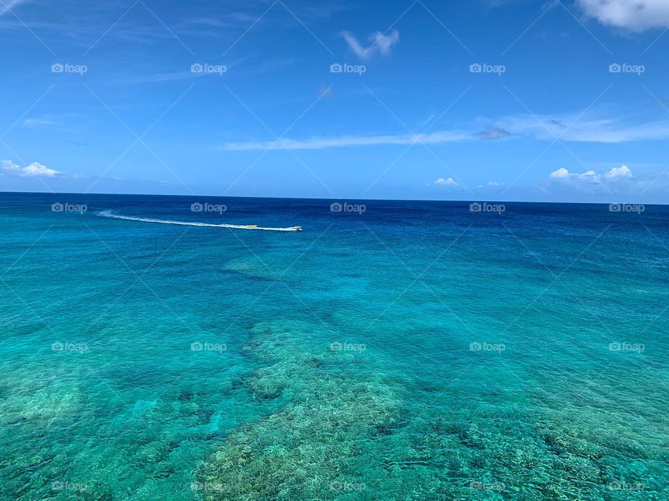 The Caribbean Sea. Blue green water with a boat sailing across