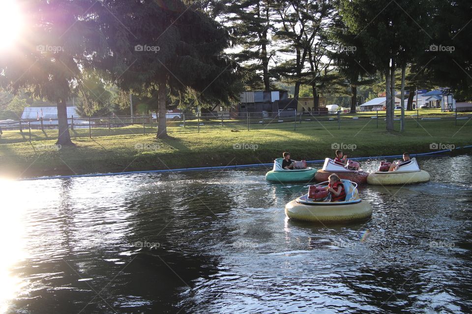 Kids riding in bumper boats in summer 