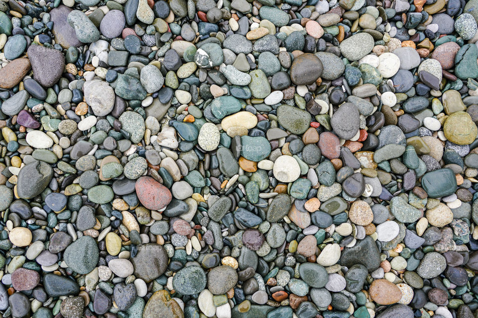 a lot of coloured pebbles on a seashore for a background of natural material