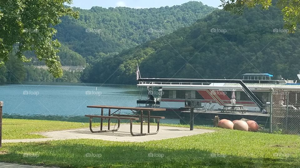 Picnic table at the lake where the family goes to cook out , play and fish