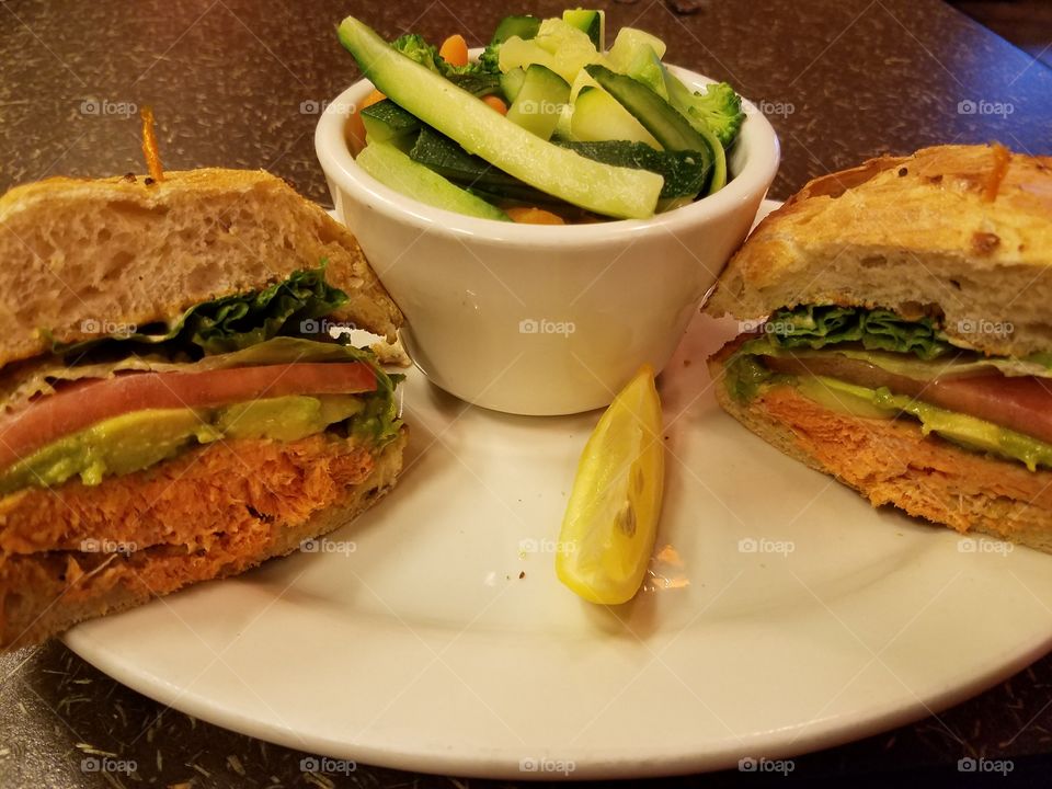 Delicious sandwich with salmon, guacamole, lettuce and tomato