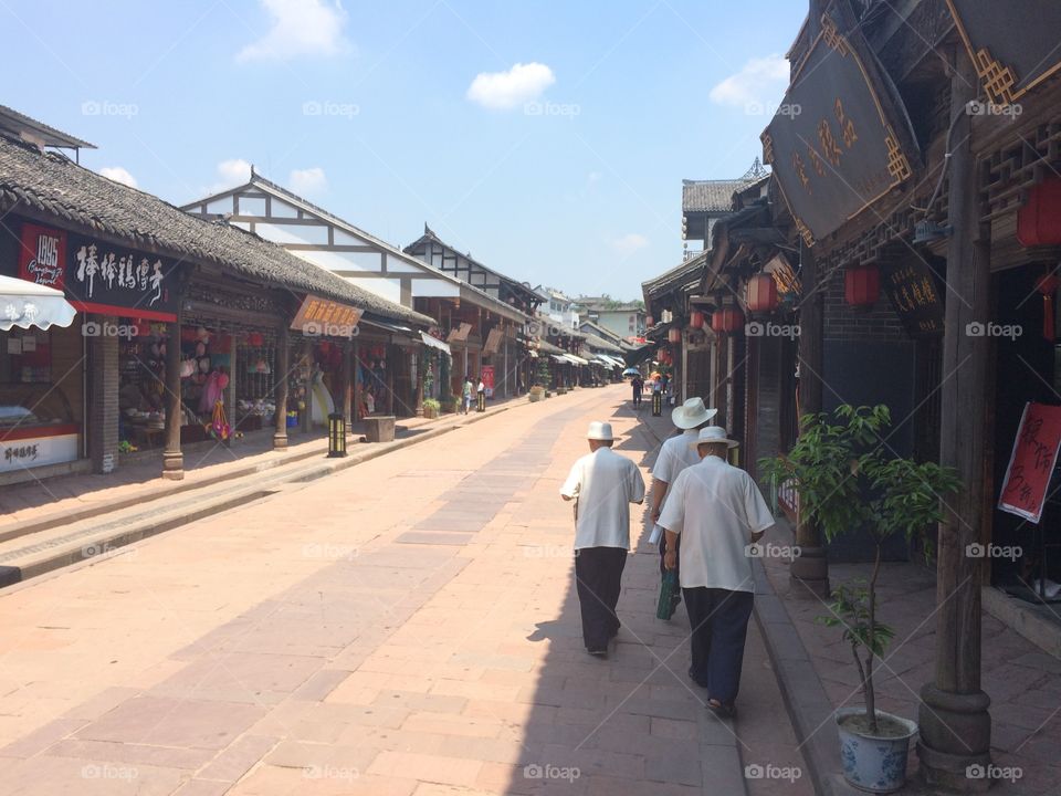 Ancient Chinese city street, men walking, blue sky