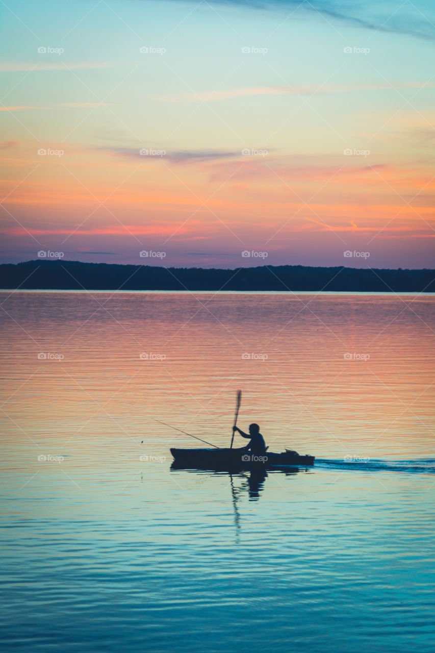 Silhouette of Fisherman in Kayak Against the Sunset on Tennessee River