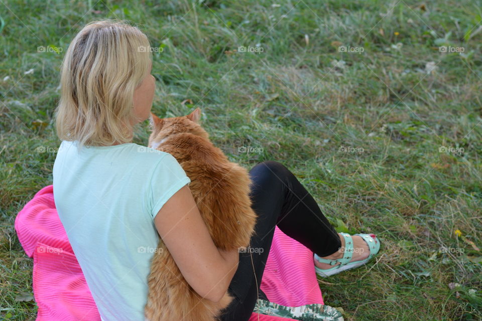 girl and cat resting on a green grass summer time social distance