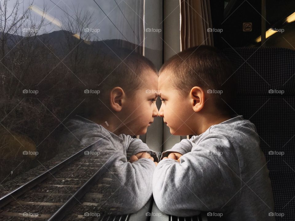 Boy looking nature from window