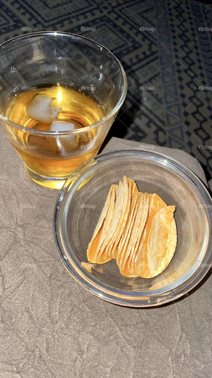 Whiskey glass with potatoes on the sofa