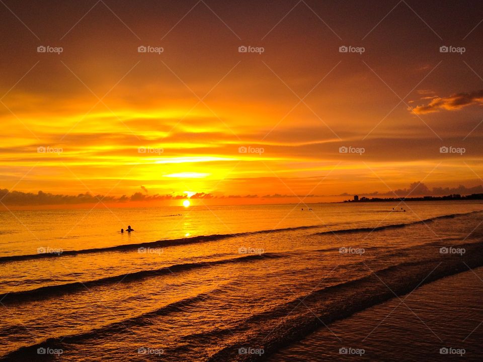 Sunset, swimmers, and waves. Sunset, swimmers, and waves