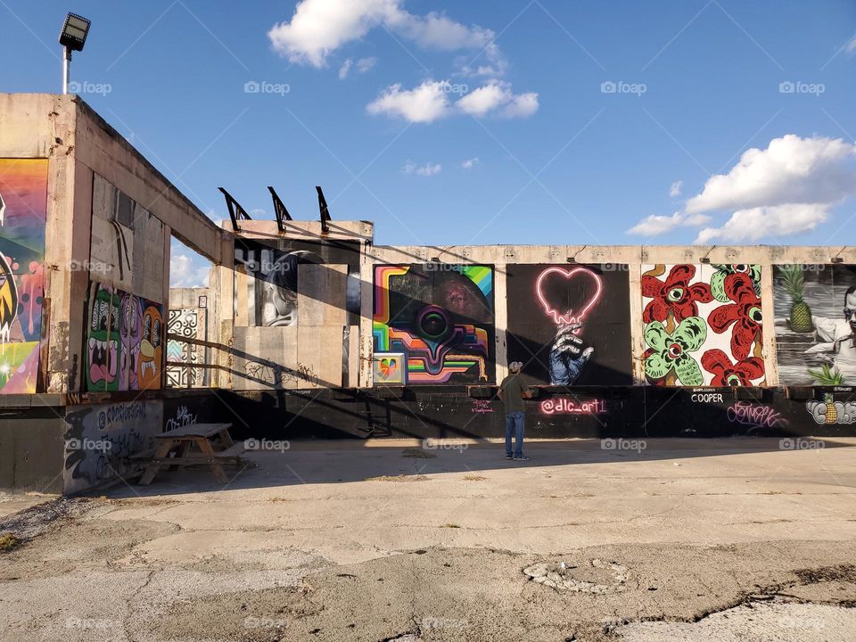 Urban landscape - A man observing art at an abandon urban outdoor art gallery.