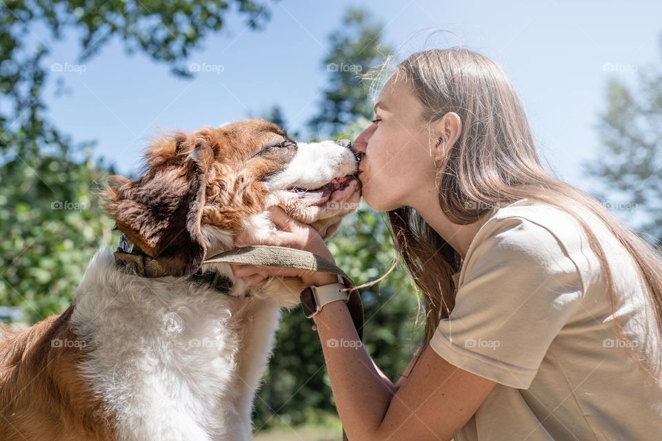 woman kissing her st Bernard dog outdoors