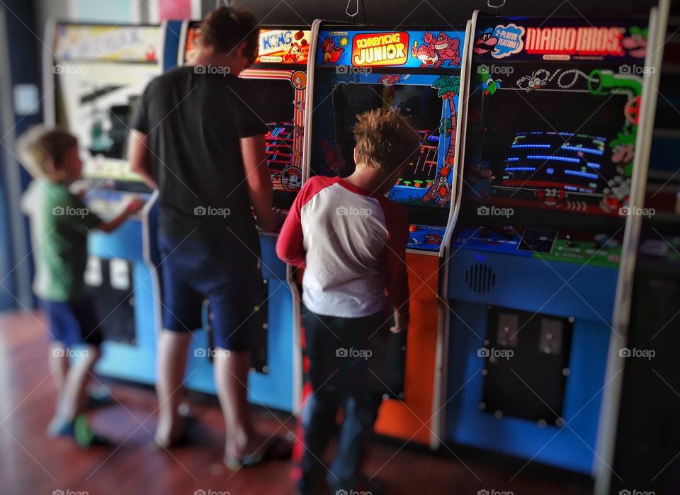1980s Vintage Video Games. Boys Playing Vintage Video Games In Nostalgic 1980s Arcade
