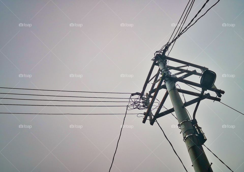 Electricity pole with wires on misty day