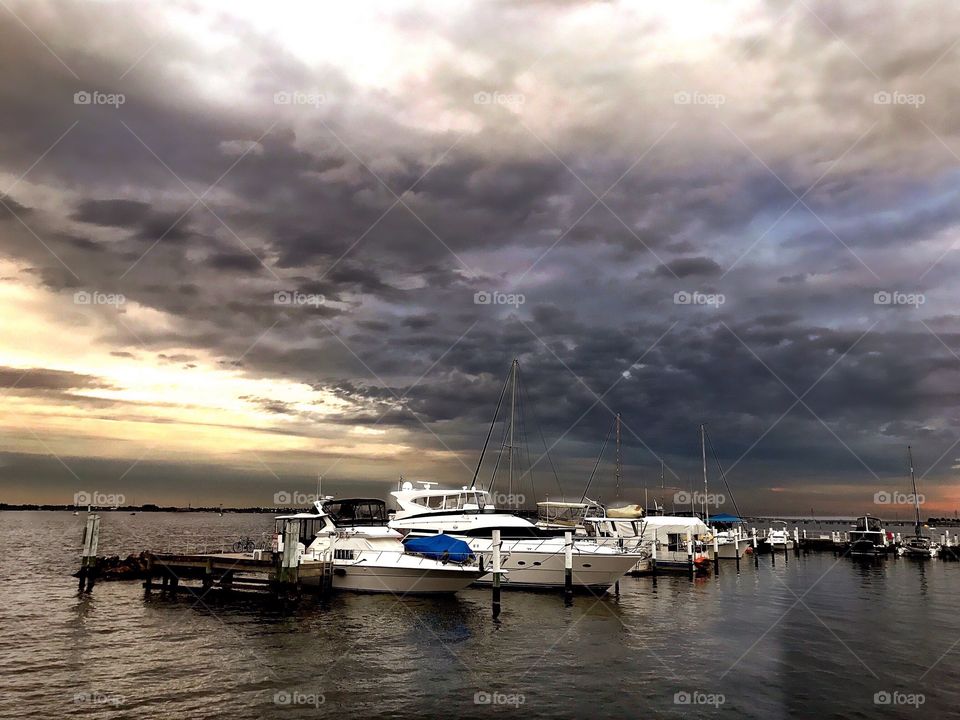 Dark ominous thunderstorms blanketing the boats and marina.