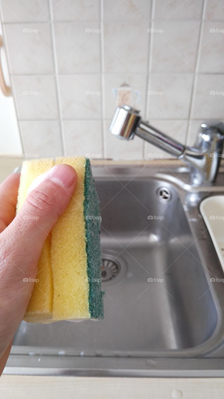 cleaning a sink with a sponge