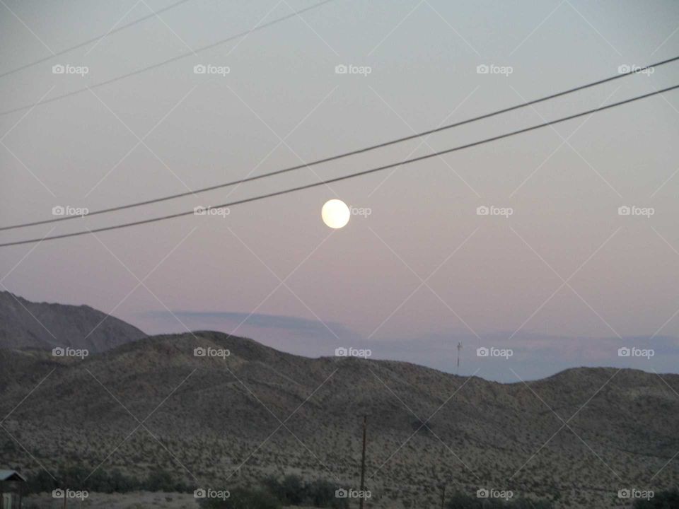 beautiful full moon in the desert sky at dusk