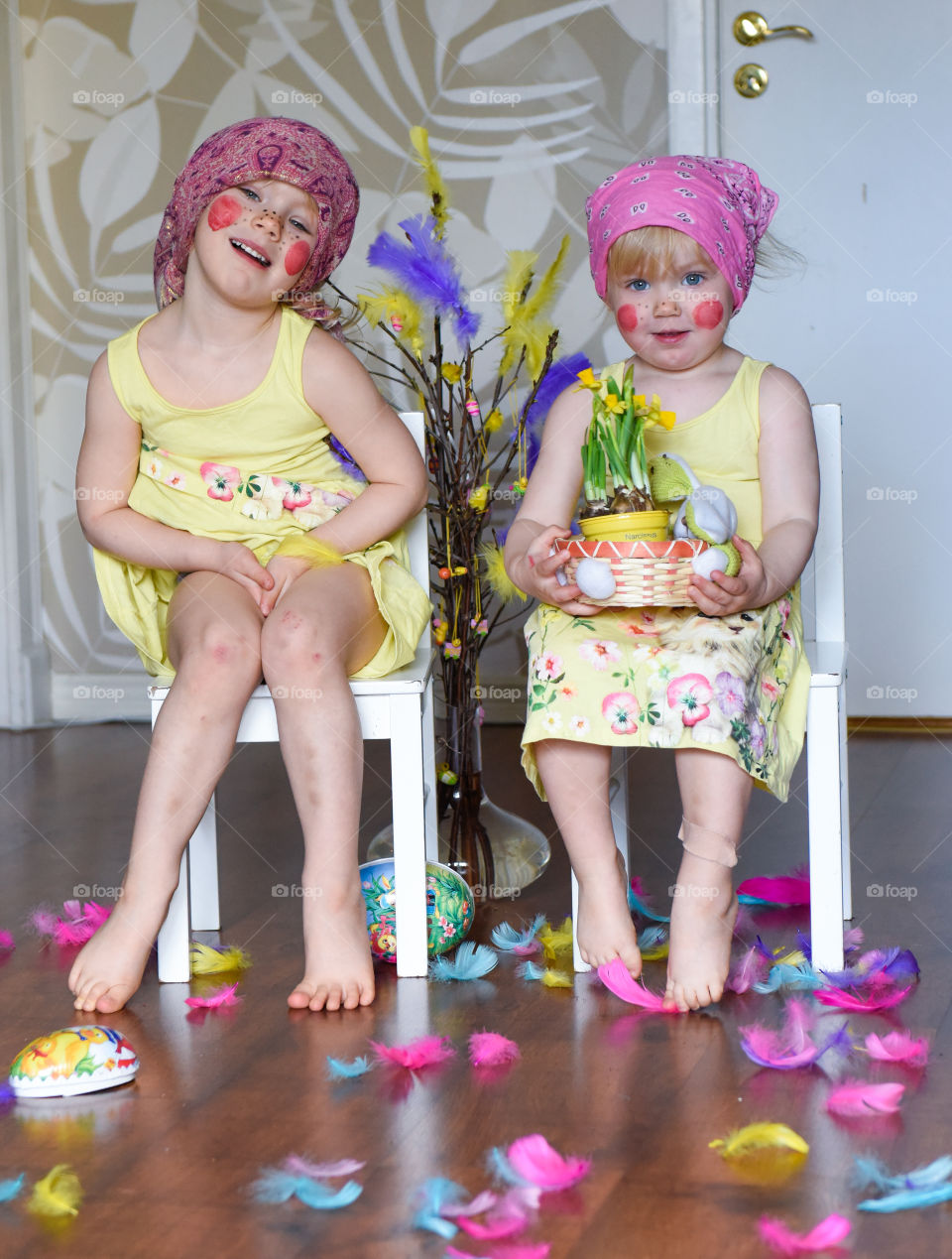 Two young sisters having fun infront of the camera with easter theme.