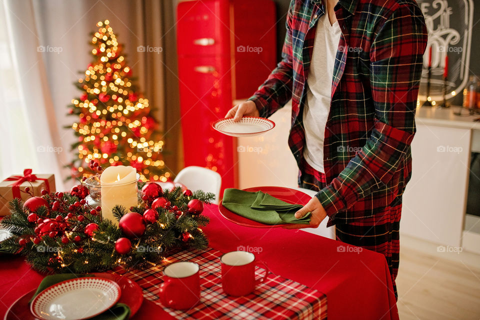 man sets a beautiful decorated winter table for a festive dinner.  Merry Christmas and Happy New Year.