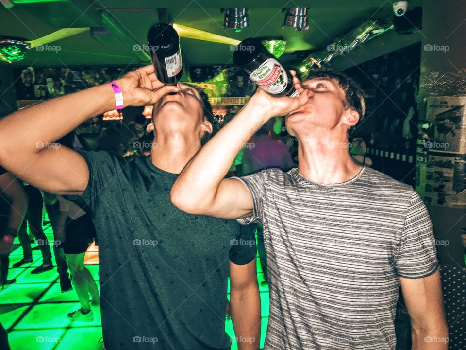Two guys drinking a beer 

