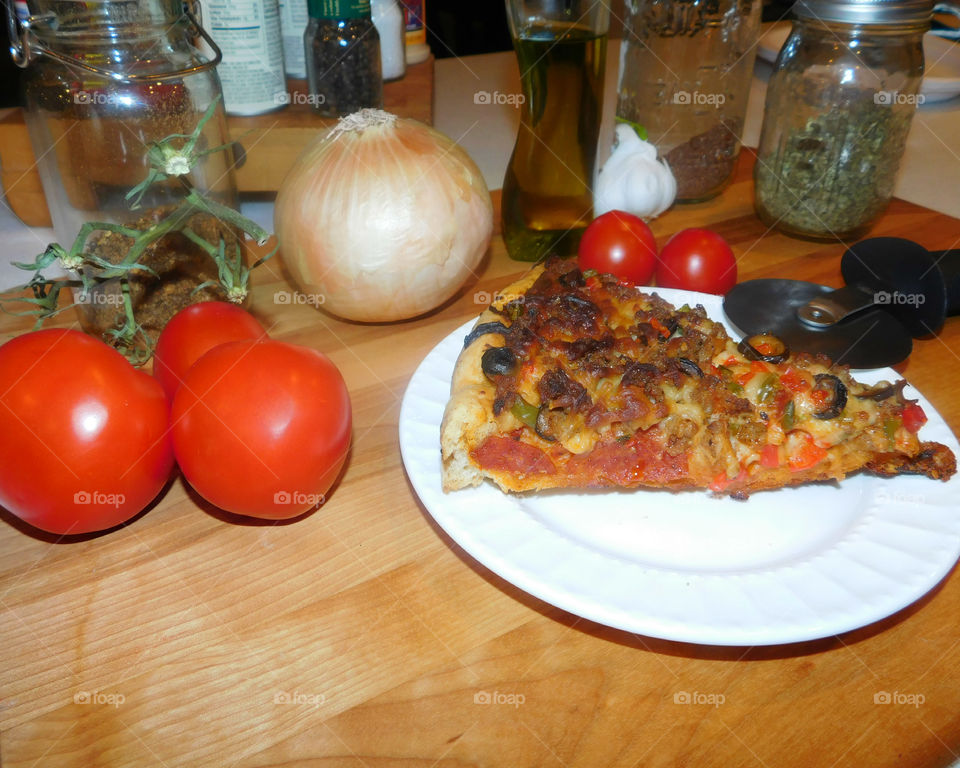 Delicious and nutritious homemade pizza with fresh, colorful vegetables, meats and a variety of spices! Grab a slice!