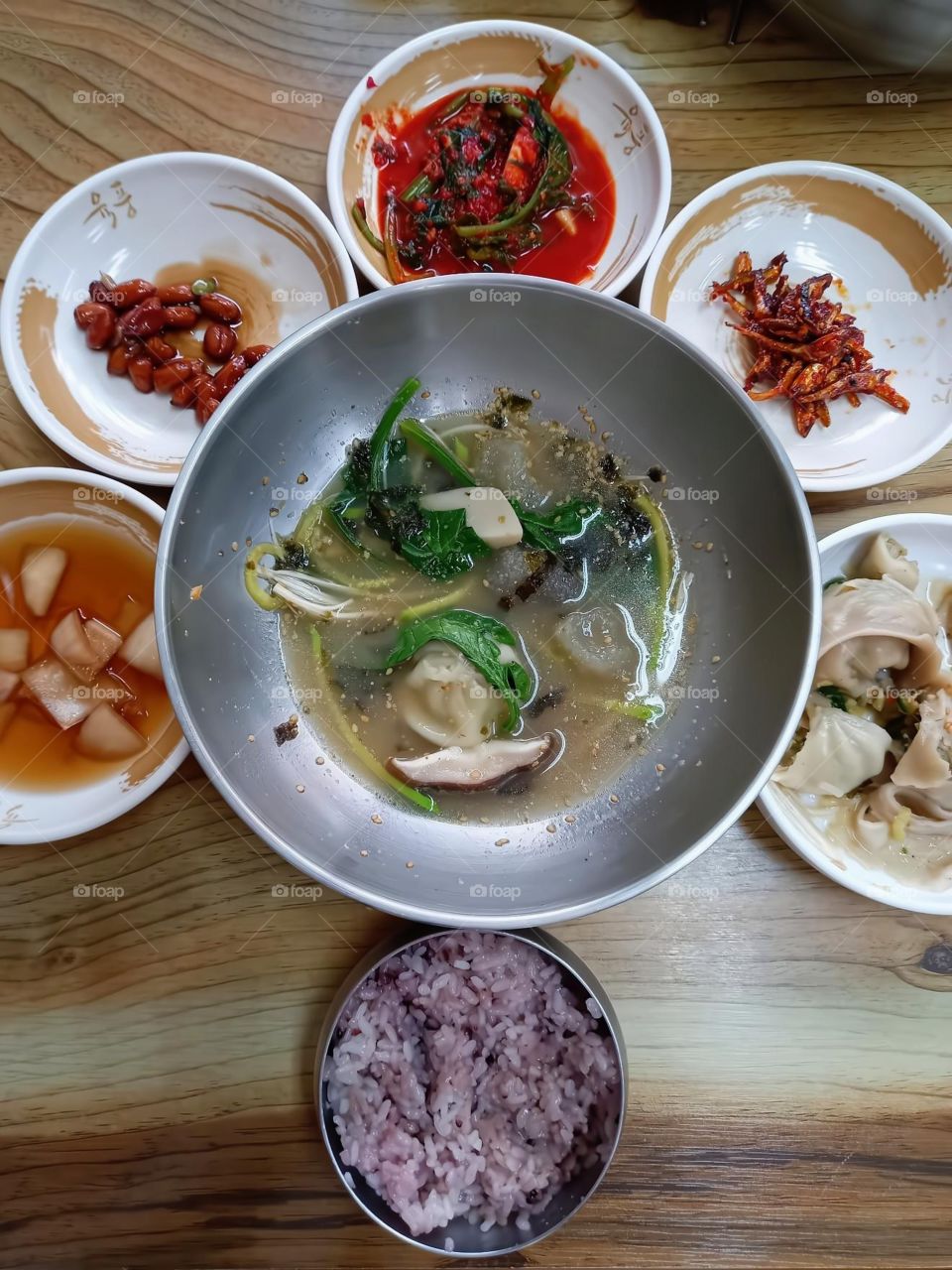 From the left.

Pickled onions.
Braised peanuts. 
cubed radish kimchi
Stir-fried anchovies. 
the center is " dumplings soup"