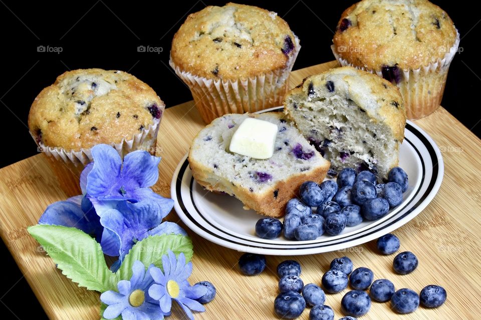 Blueberry muffins with butter and blurting a plate