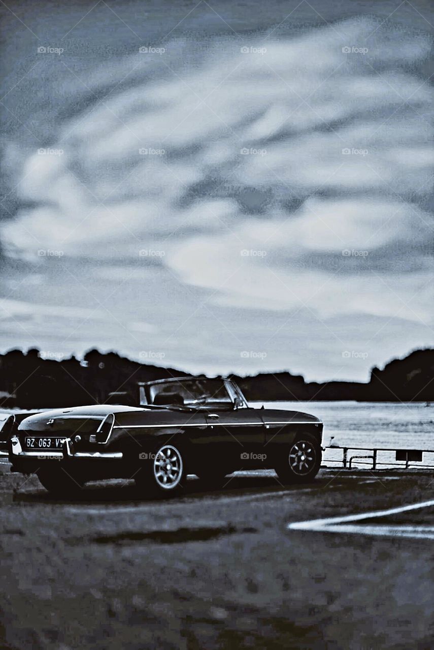 Vintage cool tone shot of an MG Convertible at dawn on Pouldu port in Clohars Carnoet