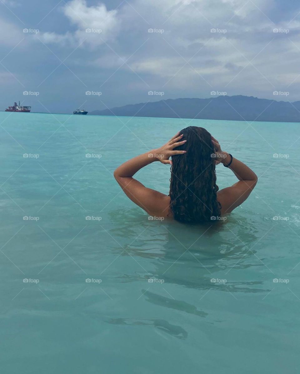 A beautiful lady at the beach swimming