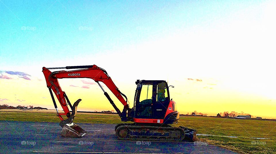Construction equipment parked at rest at sunset