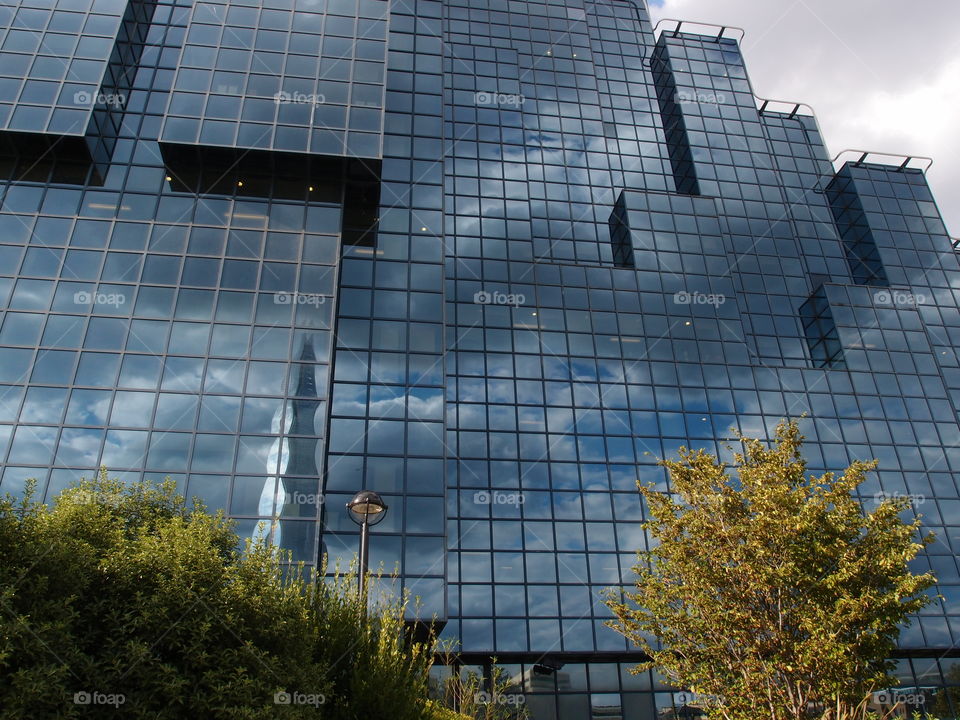 Amazing modules on a glass building in reflecting the clouds in the sky London exhibiting creative modern architecture. 