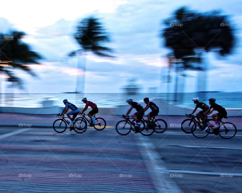 Bicycles at Dawn. Bicycle riders on South Ft Lauderdale Beach Boulevard in the light of a breaking day. 