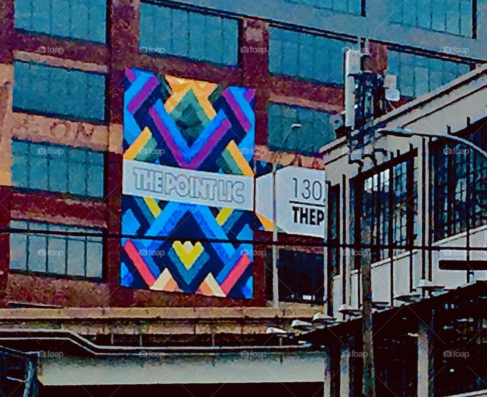 A vibrant colorful mural with fluorescence for extra attention getting is on permanent display on a Long Island City, Queens, NY industrial building near Borden Ave and the waterfront of the East River. Fall 2019. Hypnotic Productions