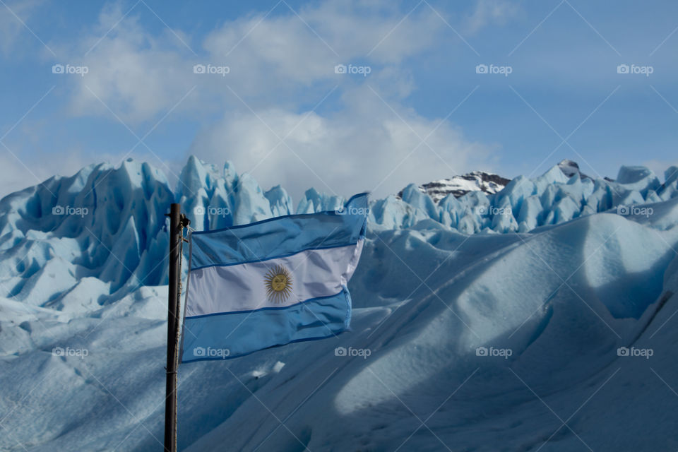 argentina flag with perito moreno glacier at back