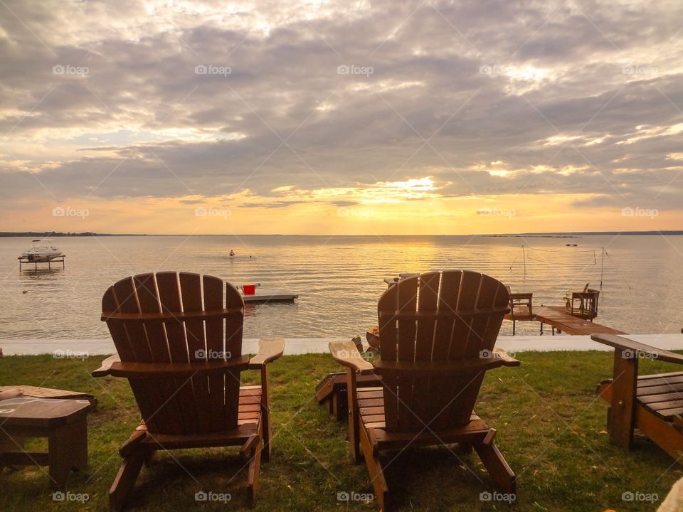 Empty chair at beach during sunset