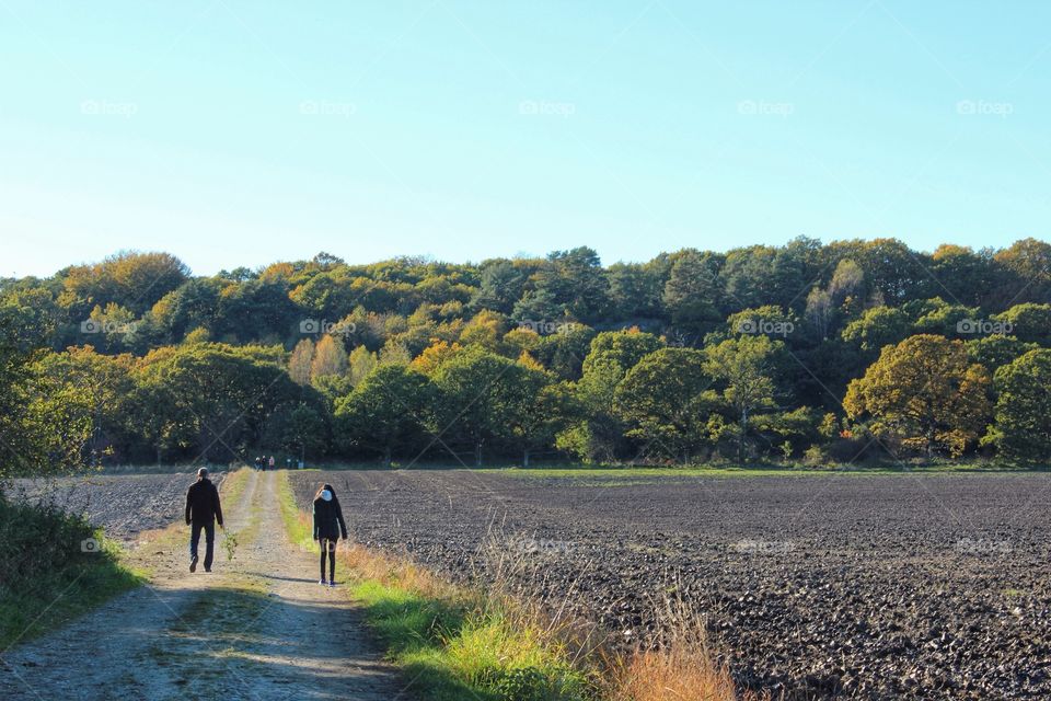 A man and a girl taking a walk in the autumn landscape