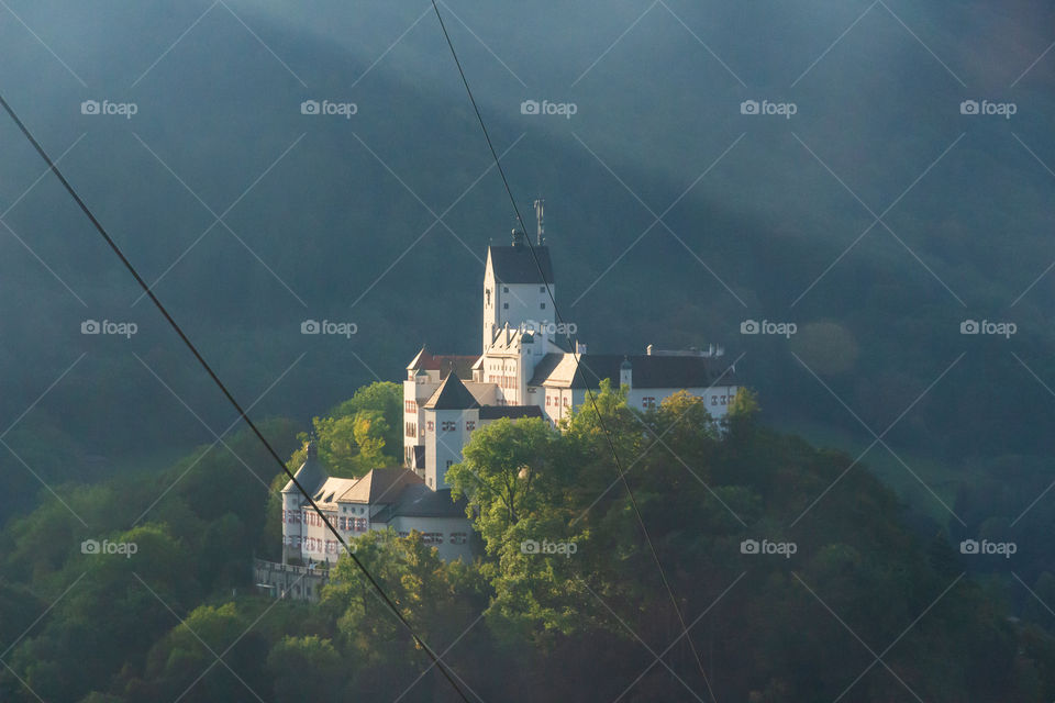 Sun shining on beautiful castle in foggy Alps , view from cable car 
