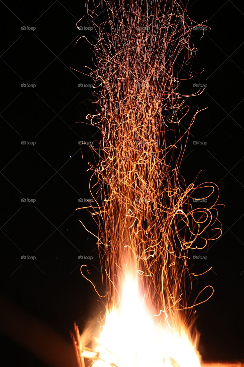 Sparks from a blazing campfire in the wild