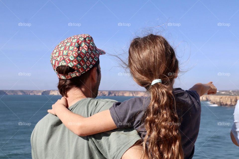 Father holds his daughter, viewing together 