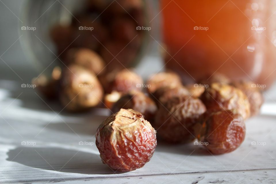 Closeup of soap nuts or soap berries on white wooden surface in natural light