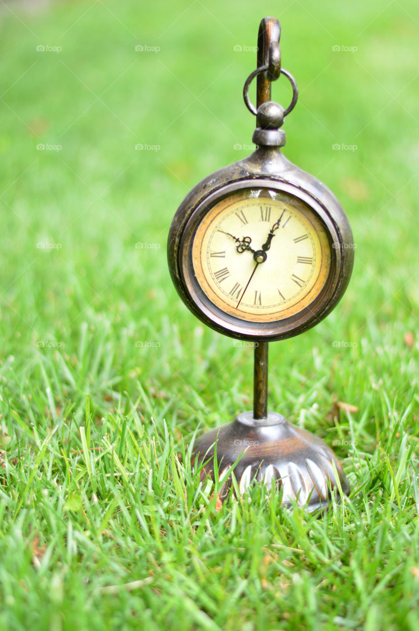 clock outside on the grass