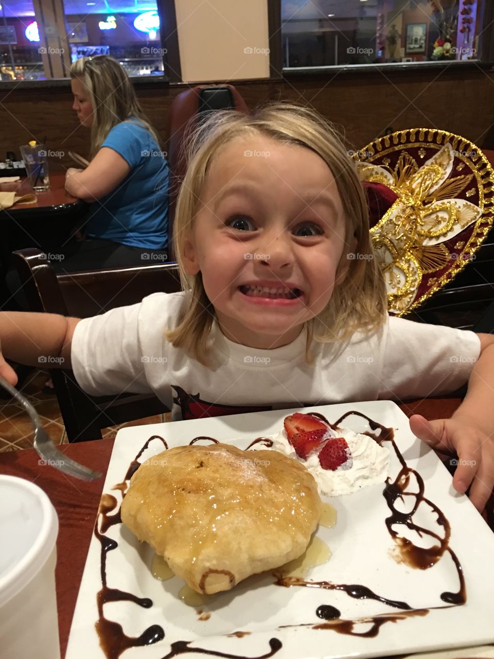 Happy girl eating sweet food in restaurant