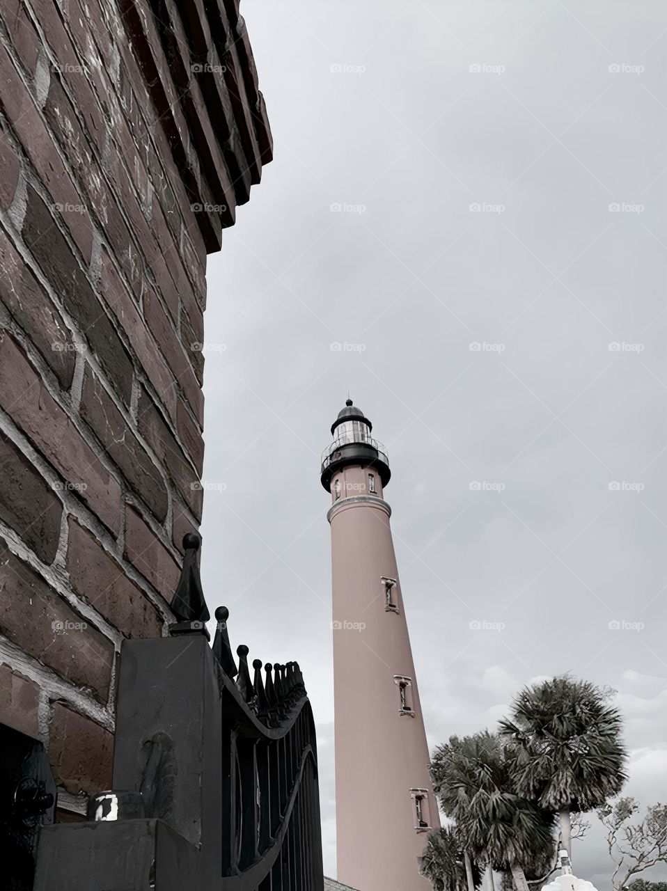 Ponce Inlet Lighthouse, also called the Mosquito Inlet Lighthouse, with brick structure and metal gate on the foreground. The current tower was lit in 1887 and stands 175 feet tall, making it the tallest lighthouse in Florida, third in the USA.