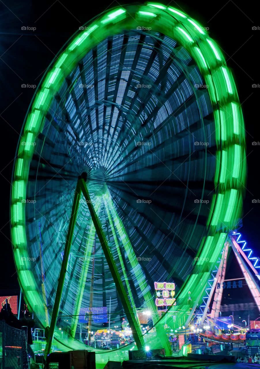 Spinning wheel . Slow mode picture of a spinning wheel and neon lights