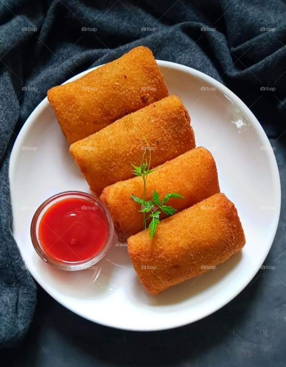 Srilankan style egg rolls with ketchup .
