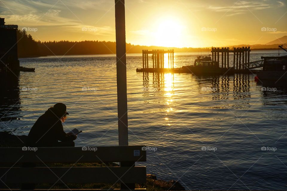 Man reading a book as the sun sets … love his backlit hair 