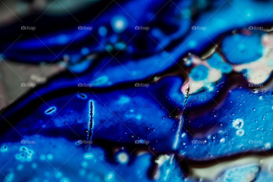 The ink to refill the printer cartridge was spilled onto the white washbasin and the paints blended into abstract drips and patterns.