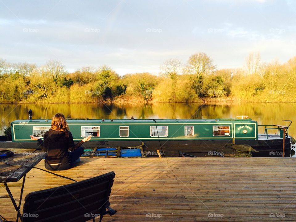 A person meditating near the lake