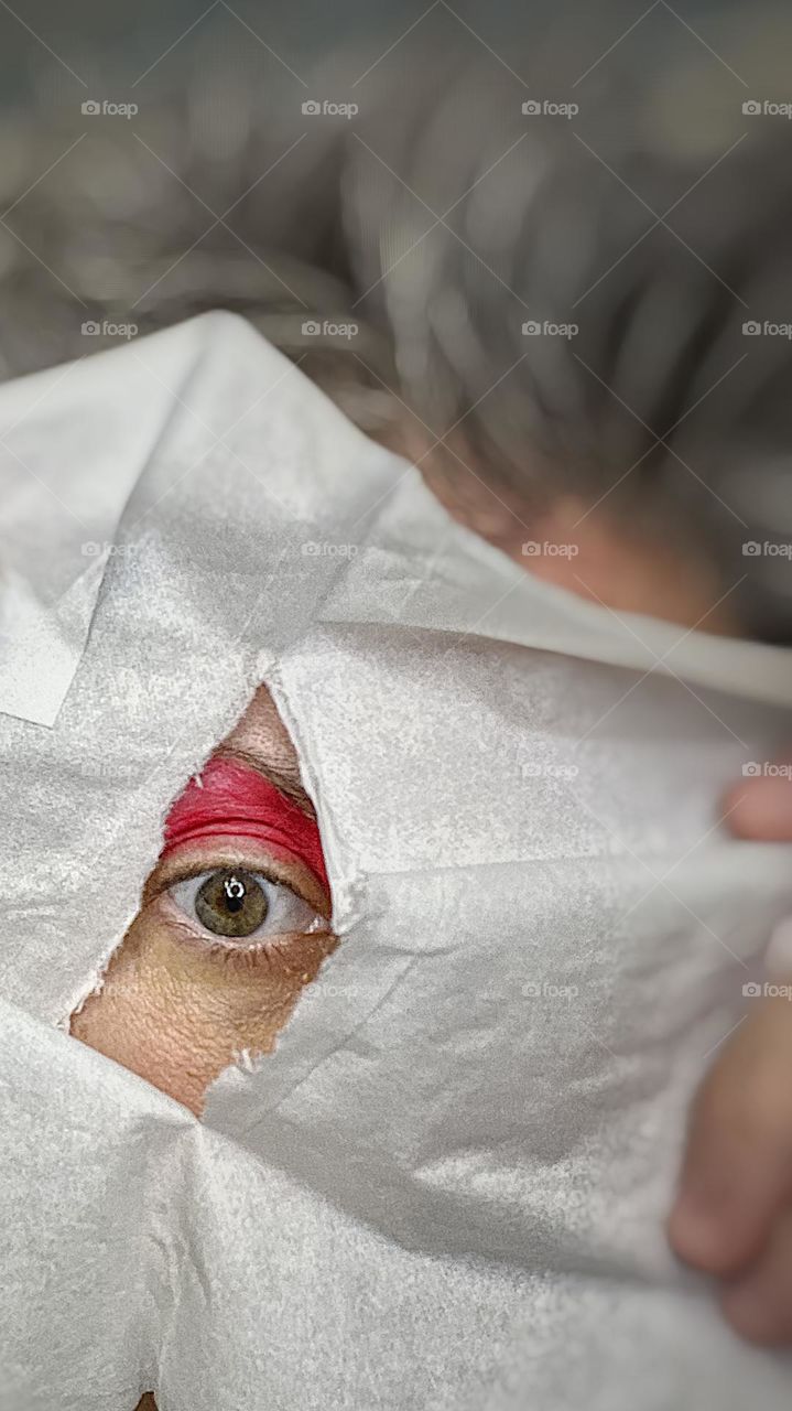 Woman’s eye peeking through white cloth, bright white cloth surrounds woman’s eye, bright eyeshadow peeks through white surroundings, ripped around all the edges, peeping through the hole in white fabric, looking at you through a hole 